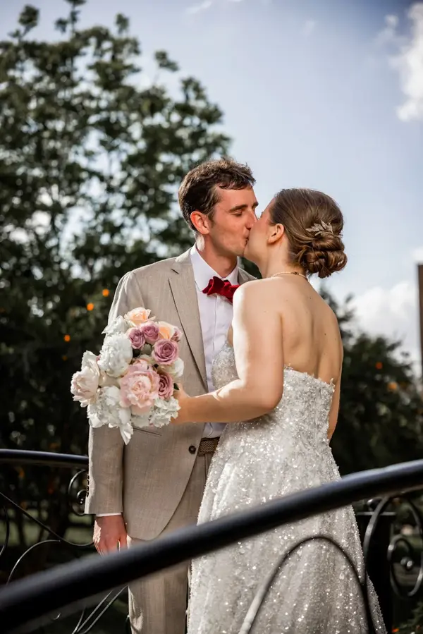 Bride and groom kiss with wedding bouquet - photographe mariage marrakech